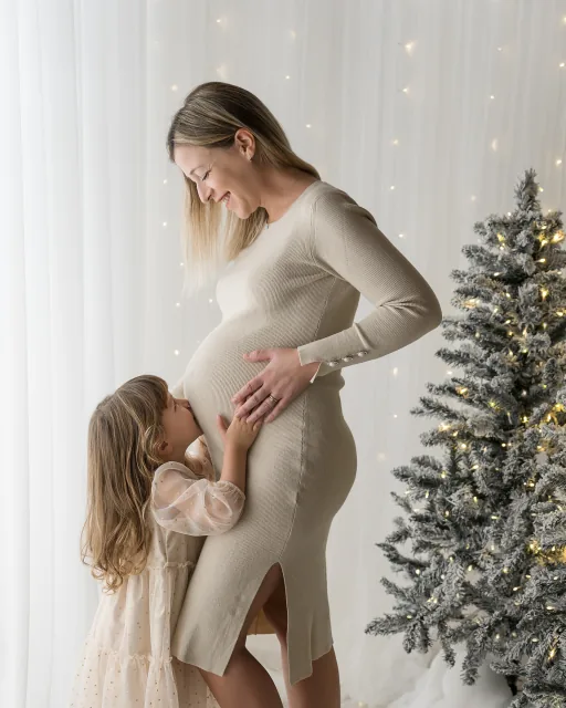Mamma in attesa con la sua bambina che le abbraccia la pancia
