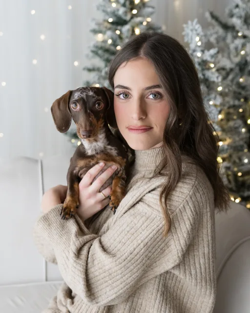 Ritratto di una donna con il suo bassotto nel set di Natale