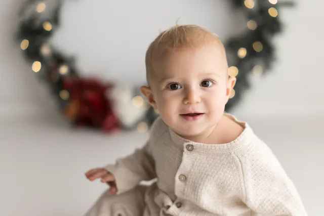 Bambino dentro la ghirlanda di Natale con un sorriso pieno