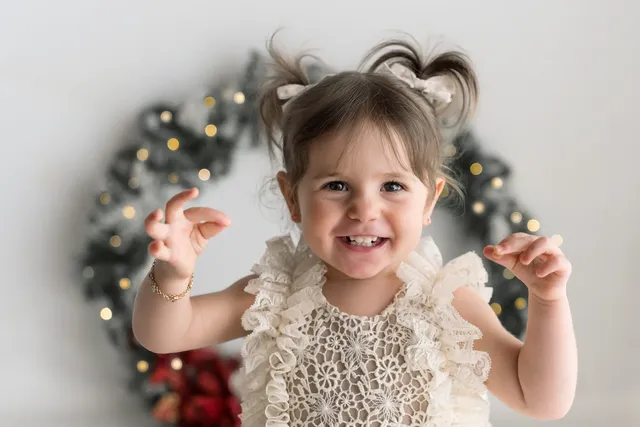 Bambina piccola dentro la ghirlanda di Natale, primo piano
