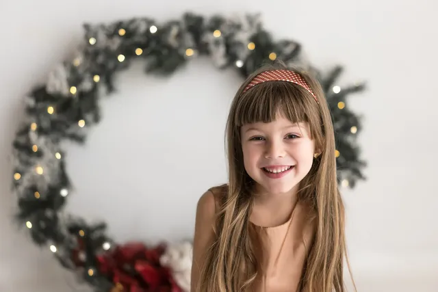 Bambina dentro la ghirlanda di Natale che sorride