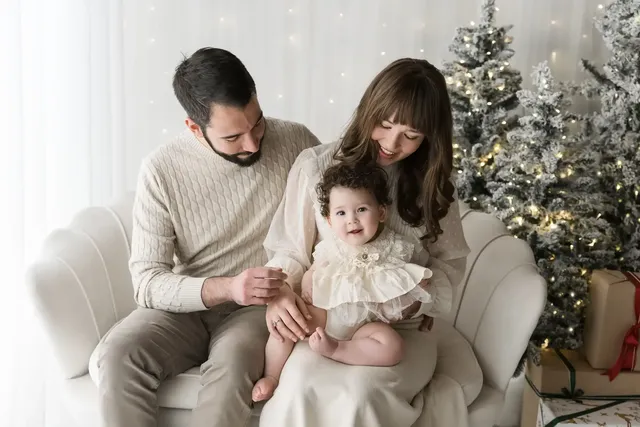 Famiglia sul divano crema con la bambina, set natalizio dell&rsquo;Atelier a Livorno